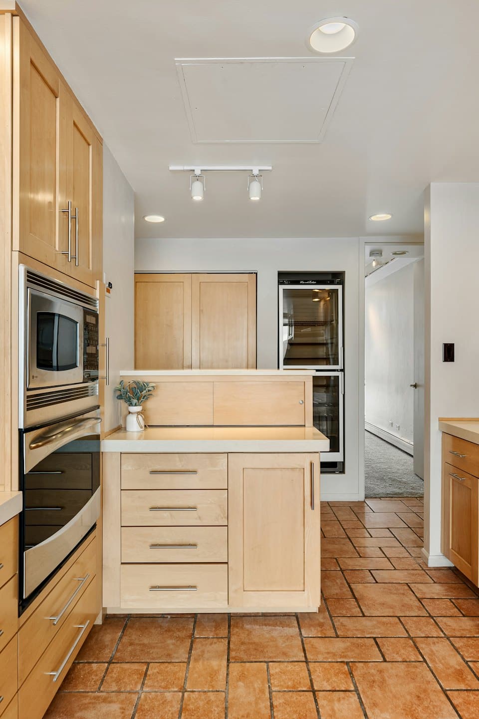 Modern kitchen with wood cabinetry and stainless steel appliances.